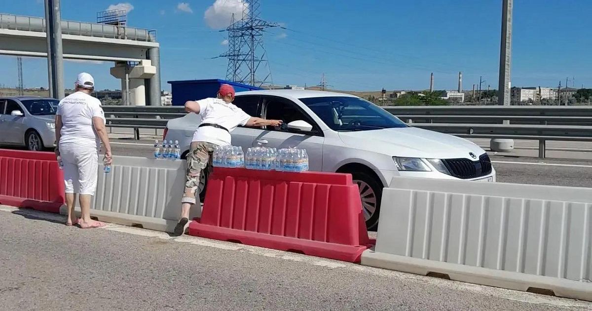 Волонтёры раздают воду водителям в очереди на Крымский мост